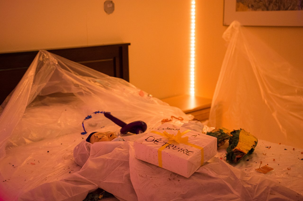 Lits de fête avec des décorations, un cadeau, et des confettis, ambiance chaleureuse avec lumière orange