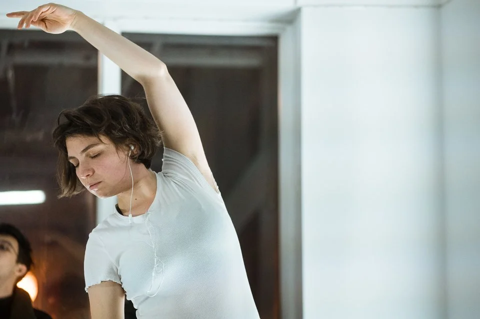 Jeune femme en studio, portant un t-shirt blanc, en méditation.
