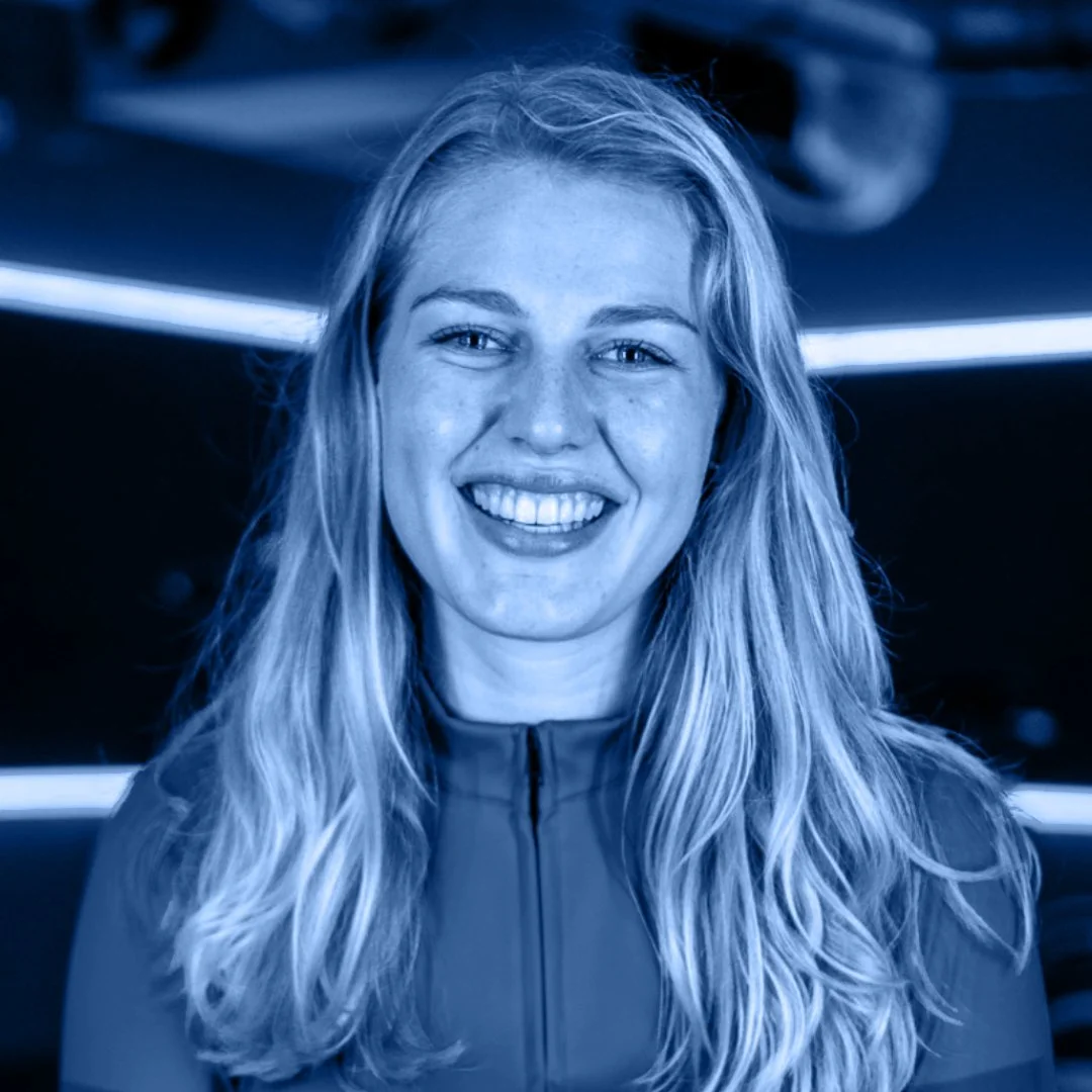 Portret van een lachende jonge vrouw met lang blond haar, in een sportkleding, op de achtergrond met neonlichten.