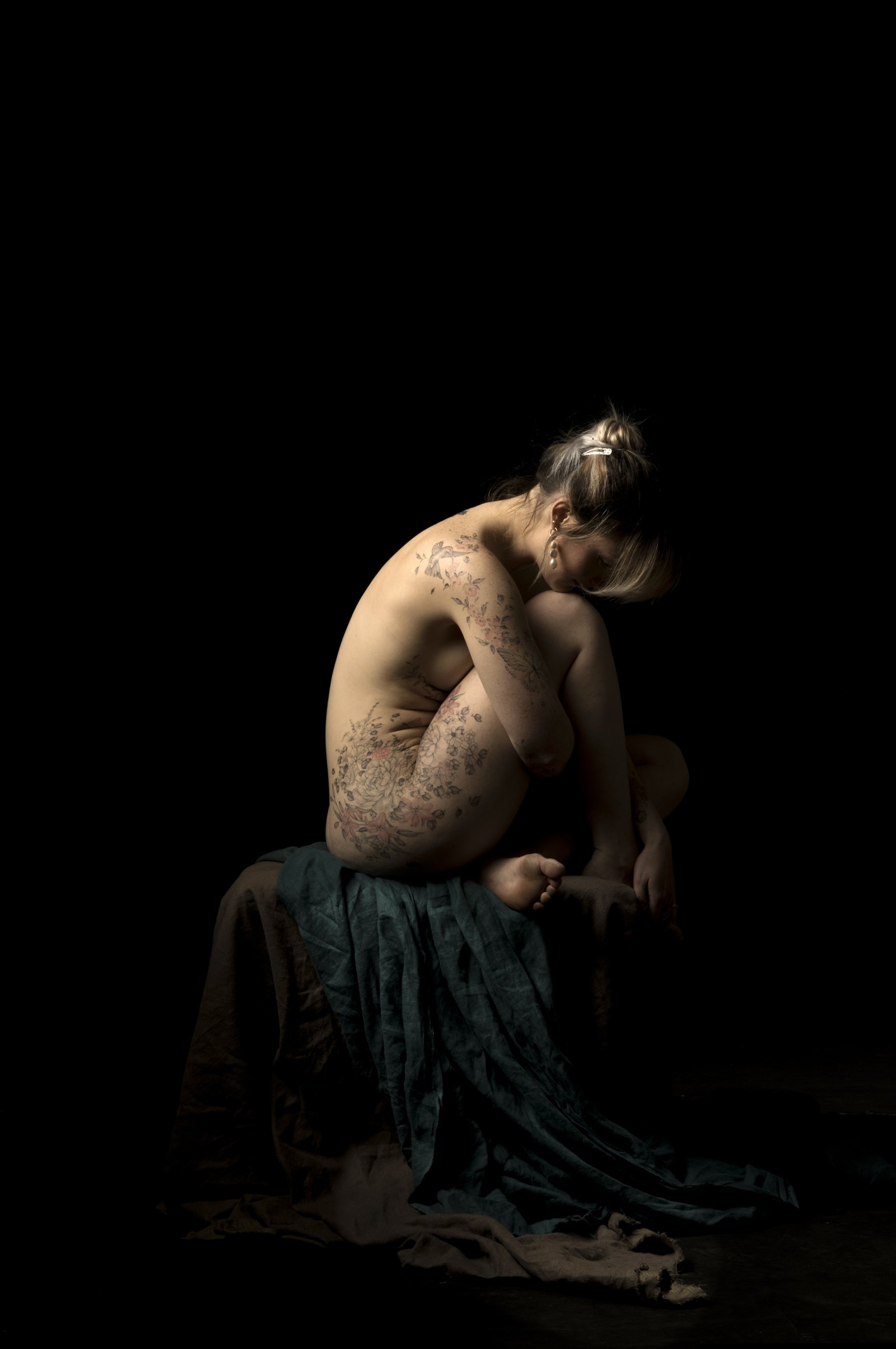 High-contrast portraiture showing a subject's form defined by sharp highlights and deep blacks.