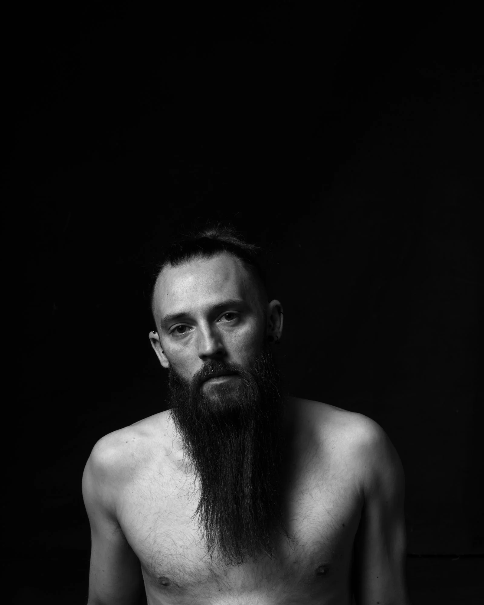 Detailed study of shadow play on skin in a fine art, dark-themed portrait setting.