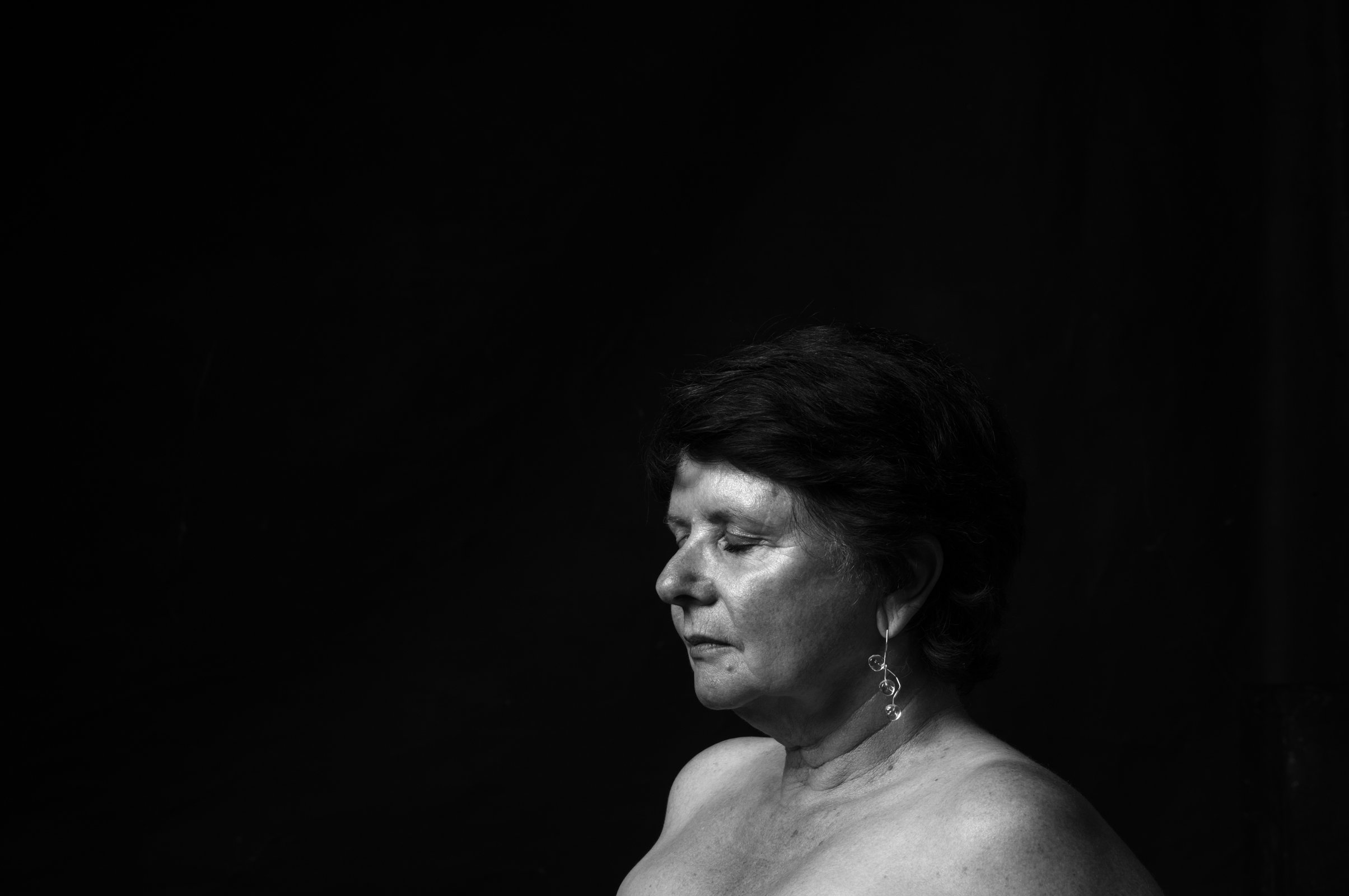 Painterly portrait of a subject partially obscured by heavy, dramatic chiaroscuro shadows.