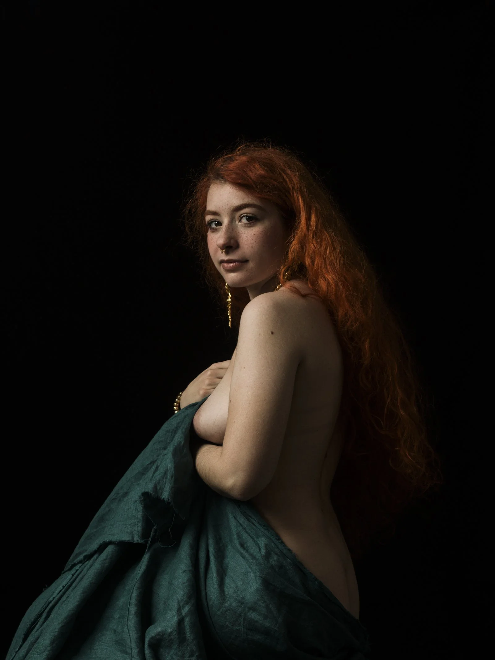 Fine art portrait in the chiaroscuro style with dramatic side-lighting on the subject's profile.