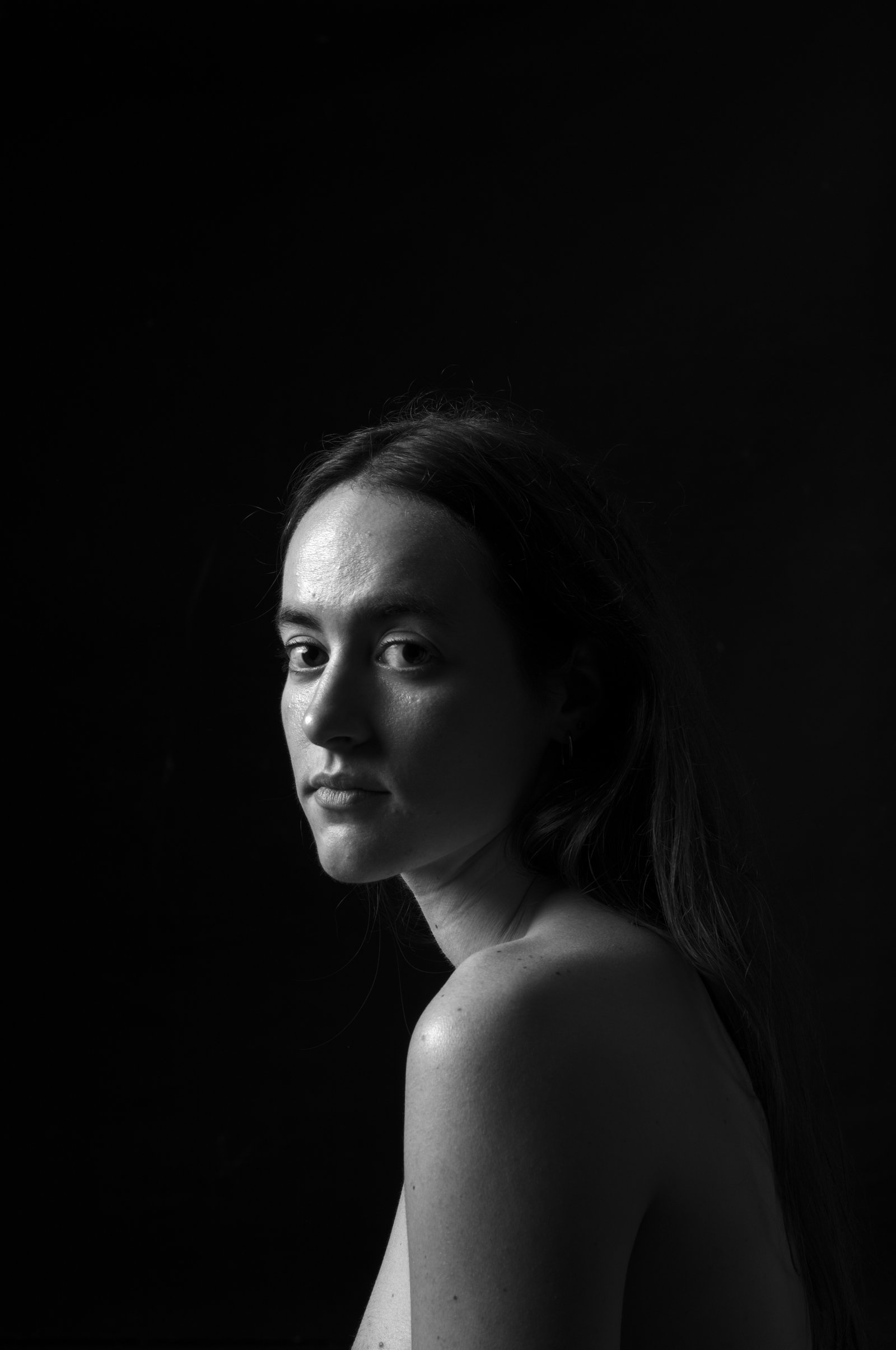 Subtle light tracing the contours of the face in a painterly People series portrait.