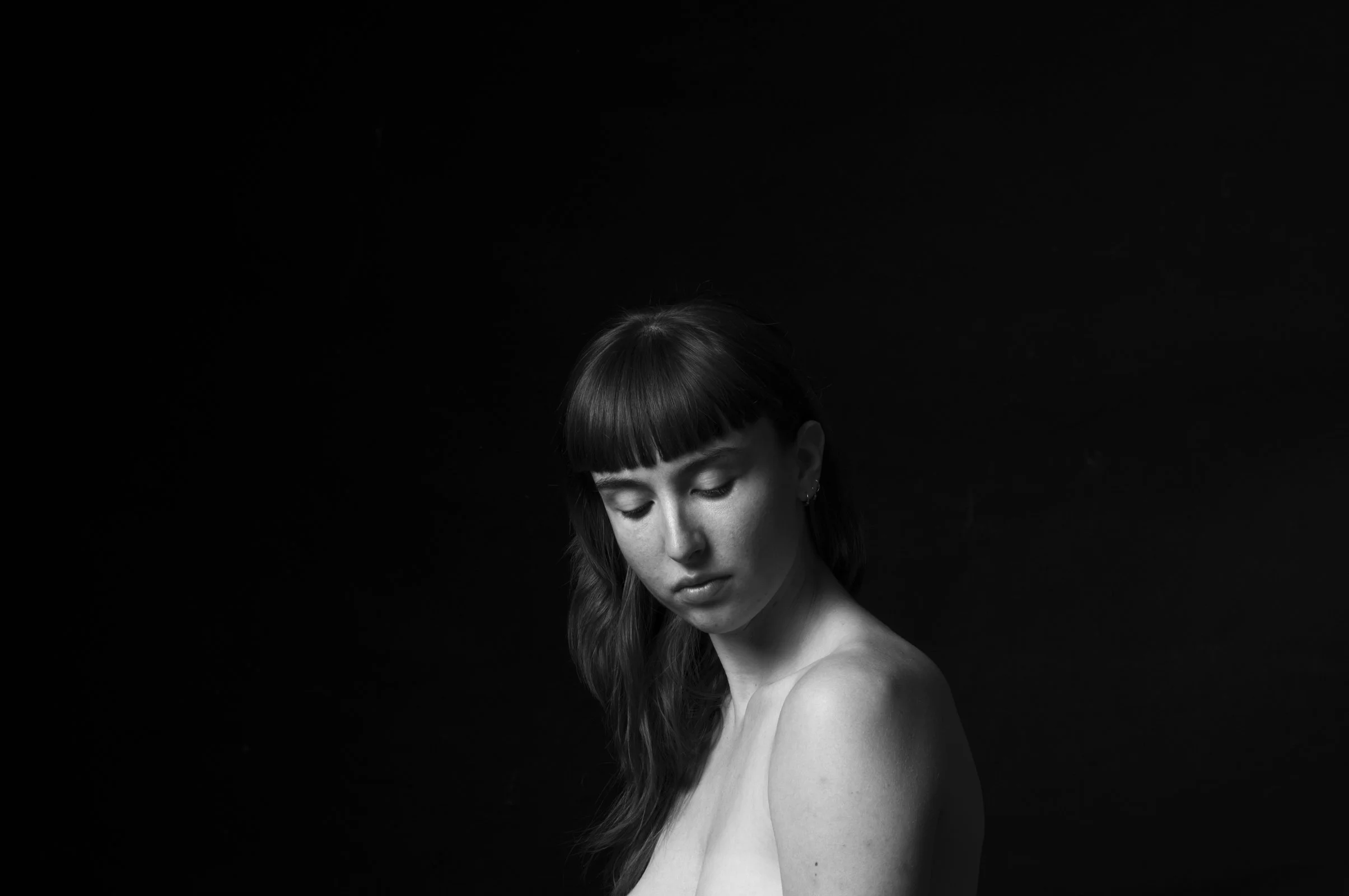 High-contrast portraiture showing the tension between light and dark on a human subject.