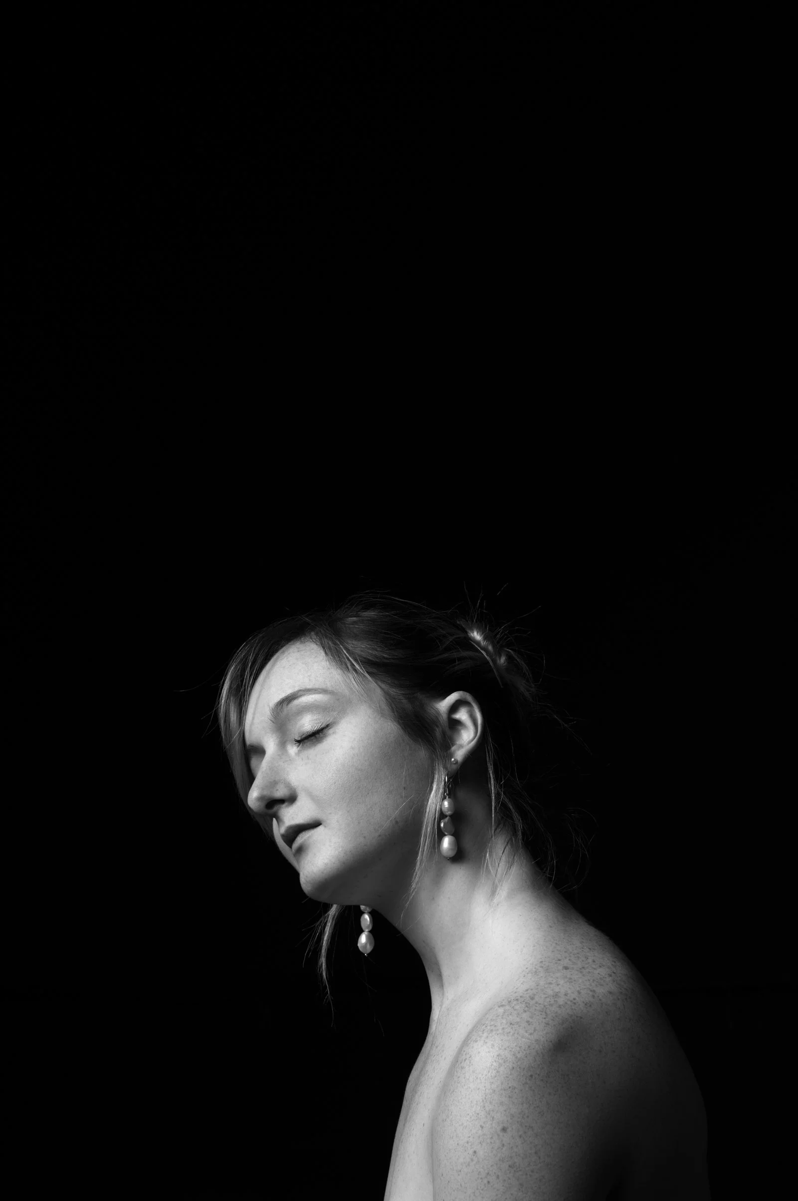 Subtle rim light defining a subject's form in the dark-themed People portrait series.