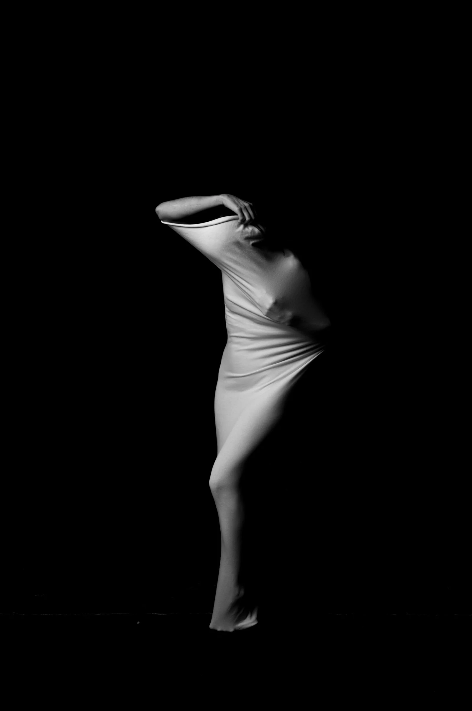 Abstract composition of a draped figure, focusing on the interplay of fabric and body form.