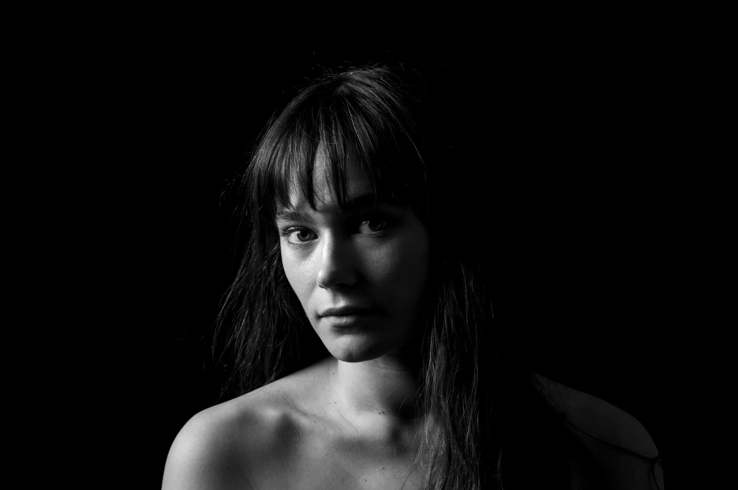 A dynamic pose in high-contrast light, part of the minimalist People photography series.