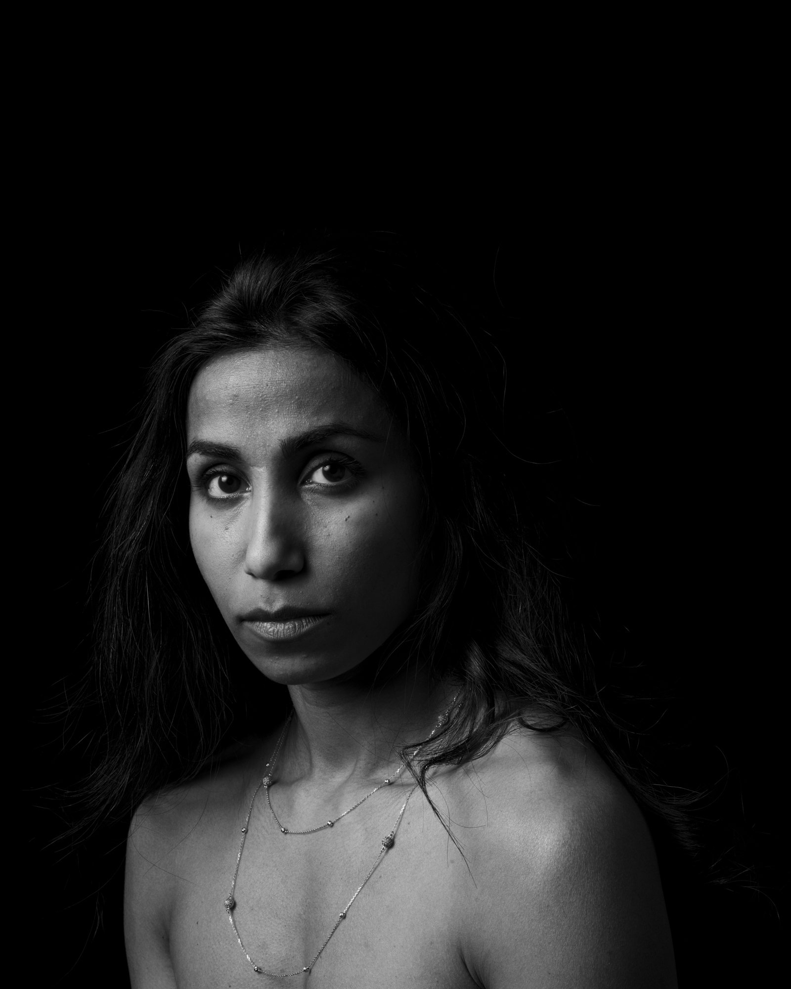 Fine art photography of skin texture and light in a high-contrast minimalist style.