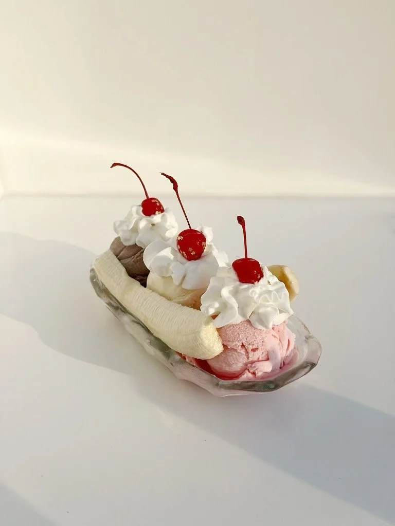 Banana split with vanilla, chocolate, and strawberry homemade ice cream with whipped cream and  cherry on top