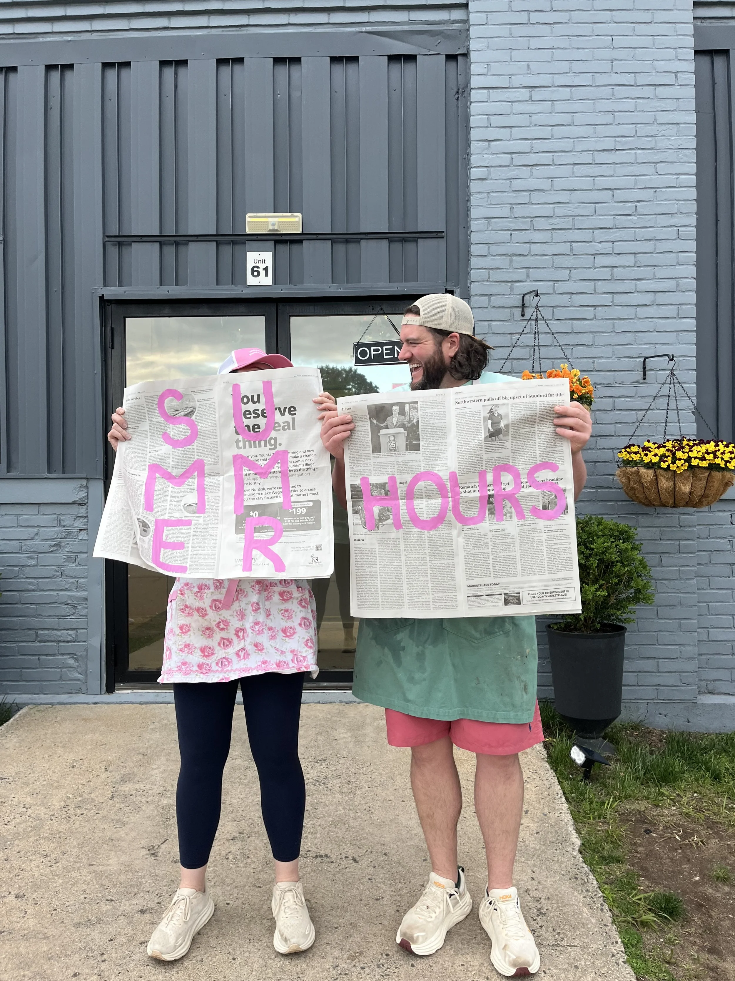 Lauren and Sean owners of Lacroix's Ice Cream in Plainville, CT standing in  front of their store holding a sign