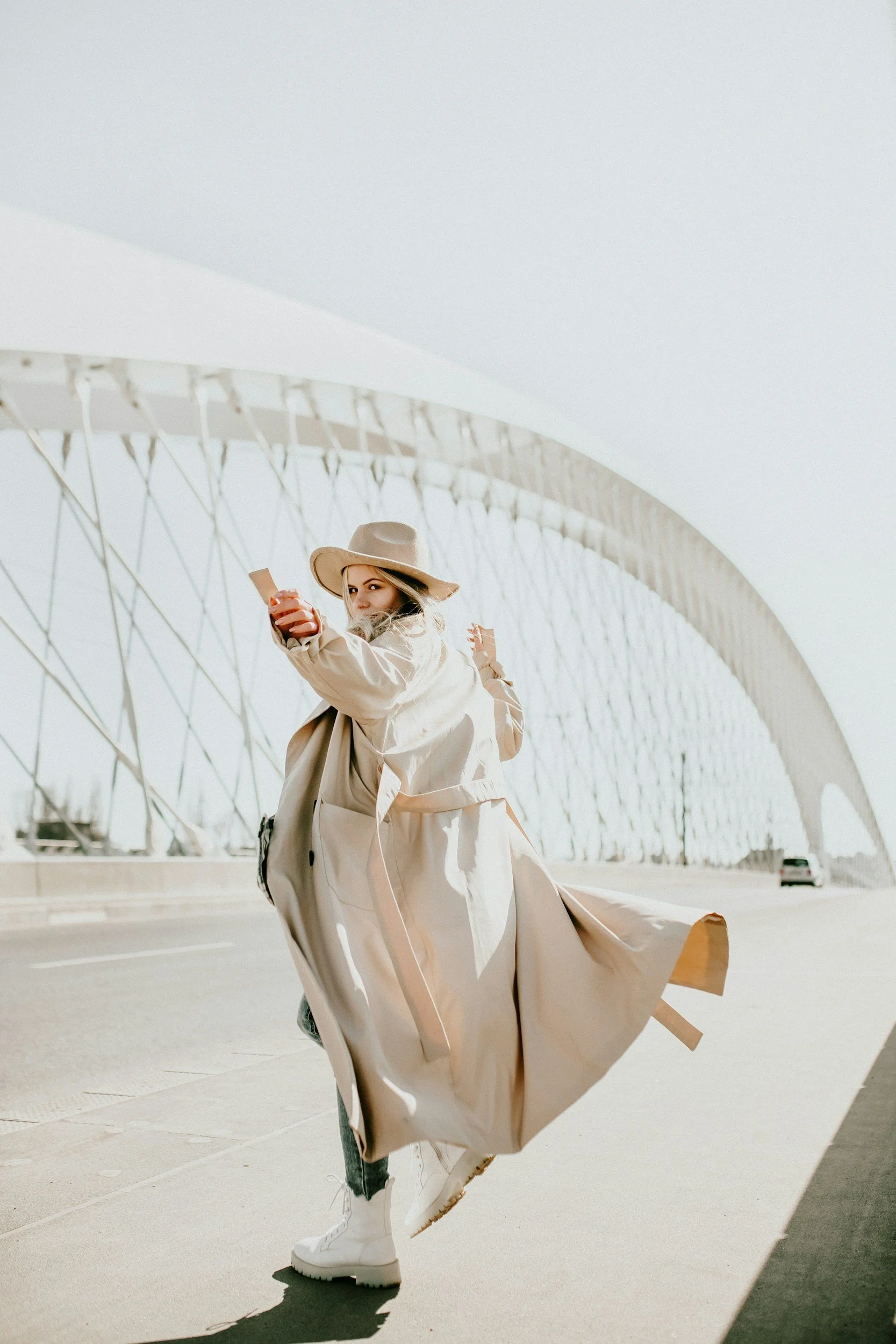Girl in a tan trenchcoat and hat turning around on a street on her way to therapy in riverside, CA