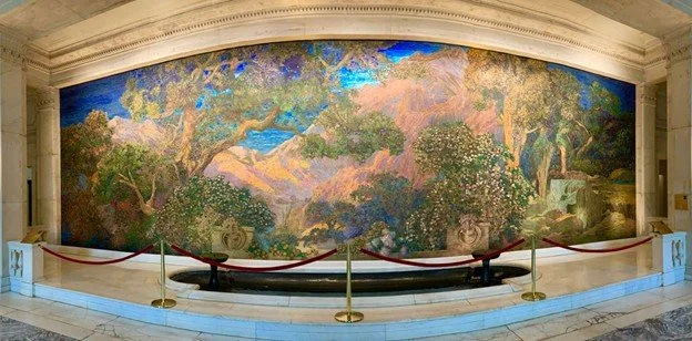 The Dream Garden Mosaic is a 15‑foot glass mural inside the historic Curtis Building in Washington Square, designed by Maxfield Parrish and crafted by Tiffany Studios. This breathtaking artwork — made from more than 100,000 pieces of hand‑fired glass