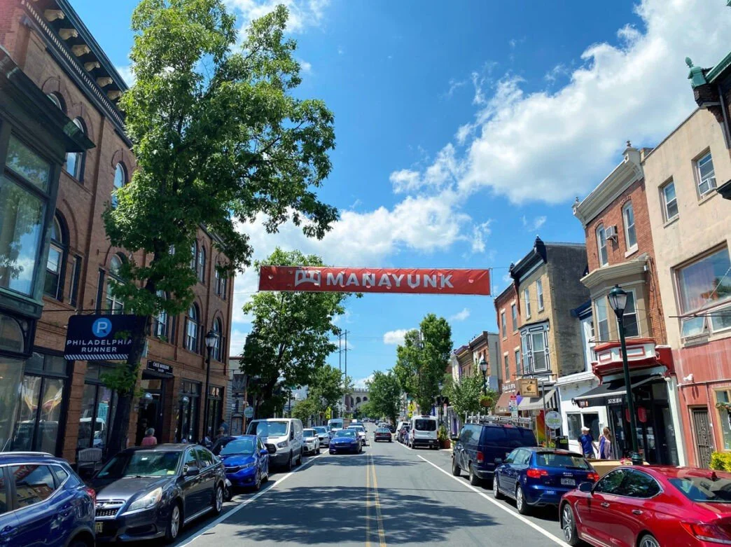 Manayunk is a hilly, historic neighborhood with boutiques, bars, and a scenic canal path. It feels like a small town within the city and is great for shopping, dining, and outdoor activities.