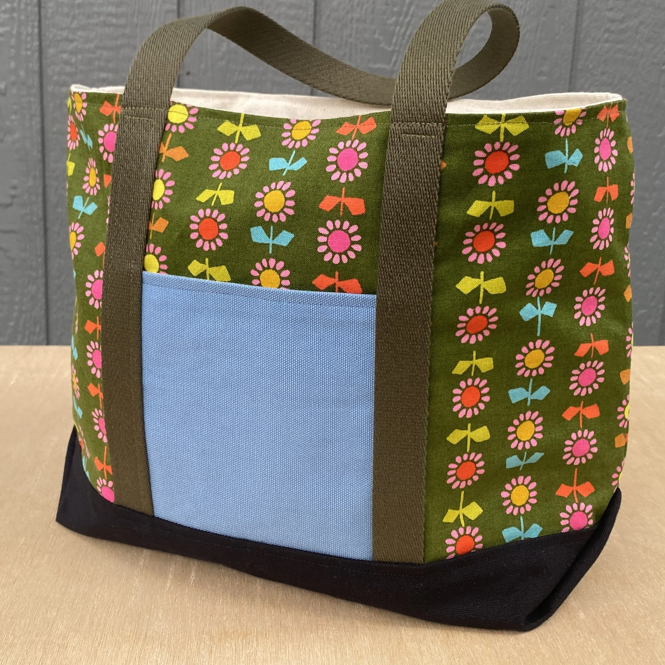 A tote bag with a colorful daisy pattern.