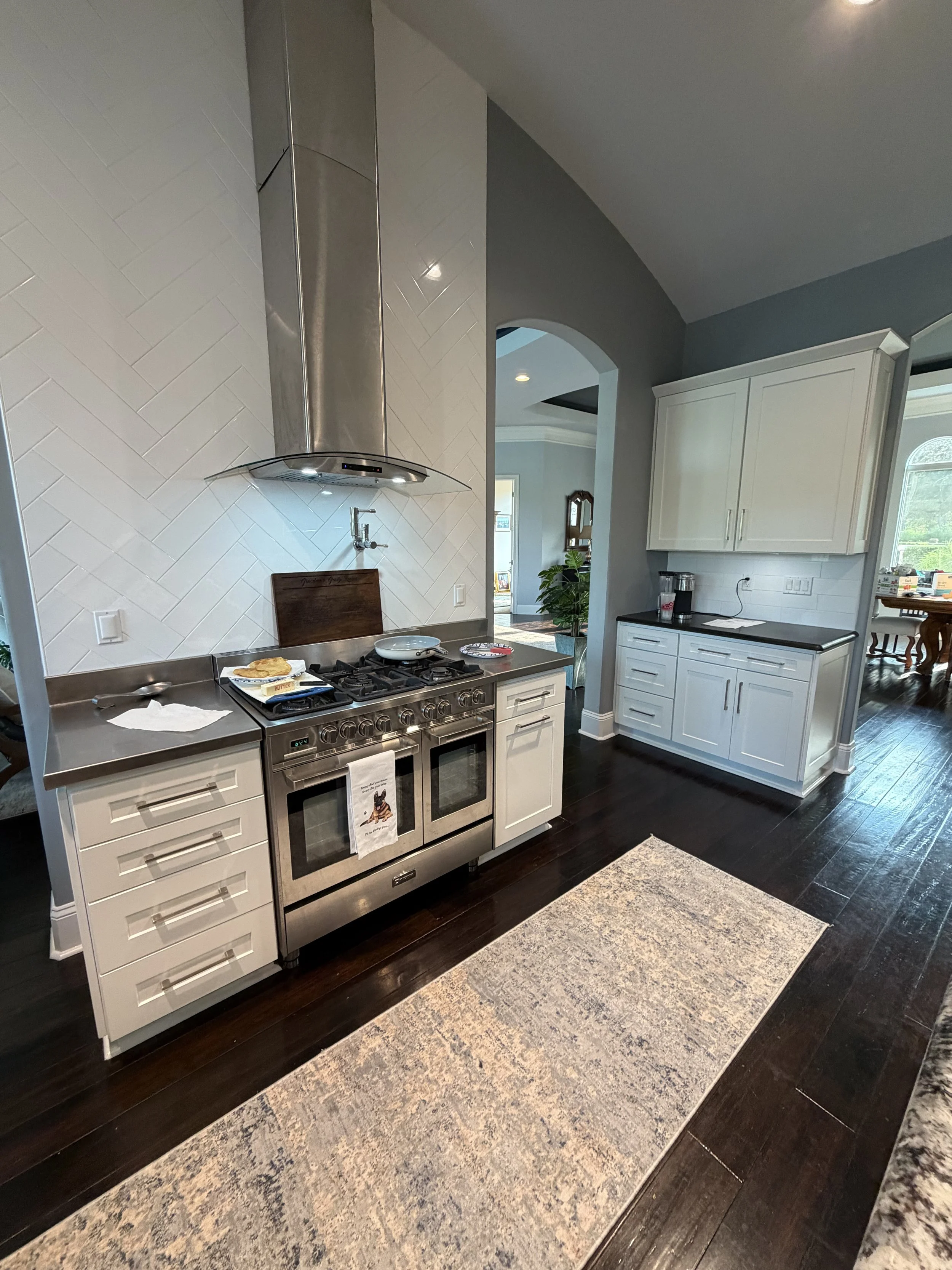 Kitchen transformation with refinished white cabinets and dark wood floors