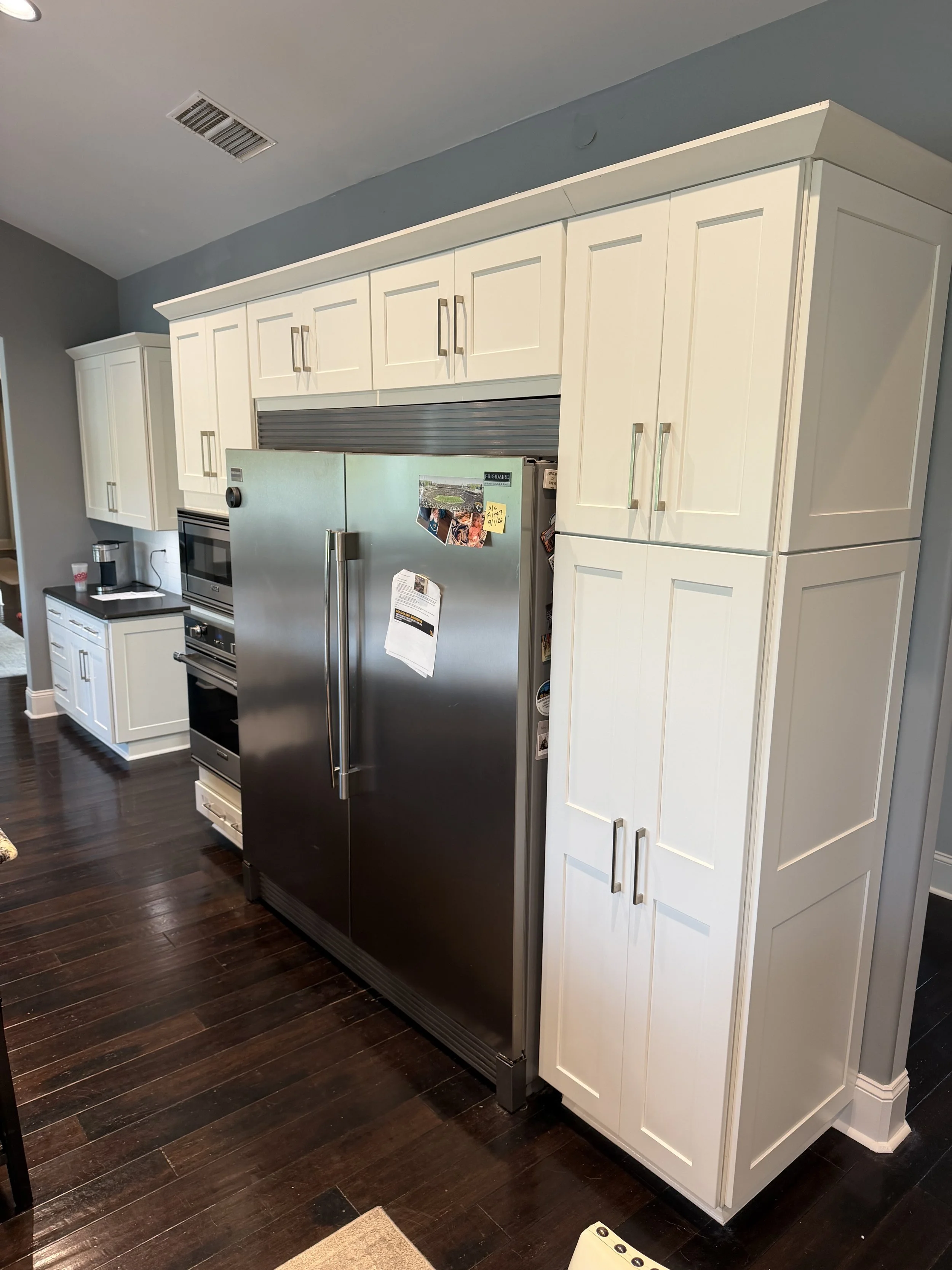 Refinished white kitchen cabinetry with tall pantry cabinets