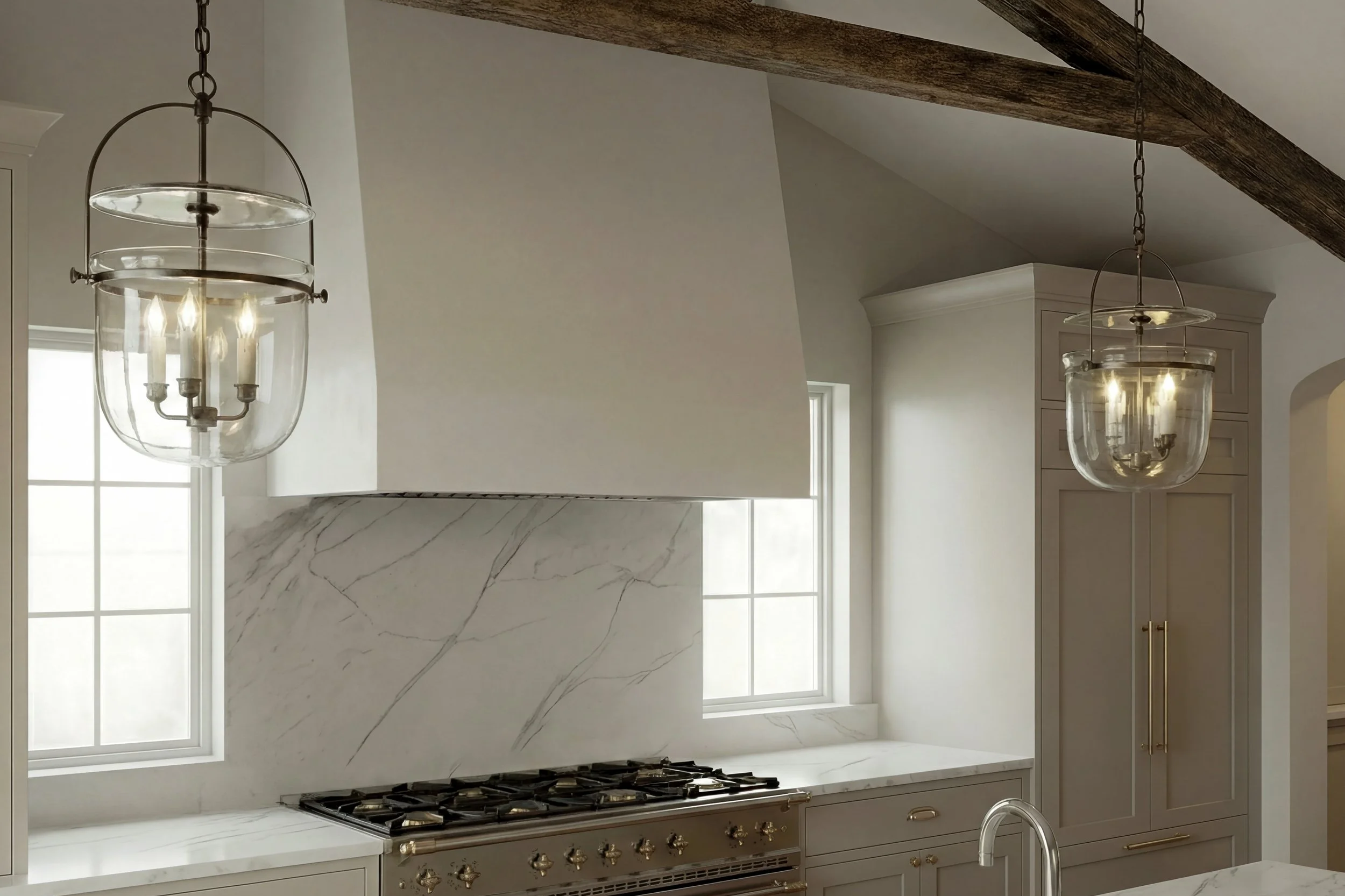 Modern kitchen with white marble countertops, a stainless steel stove, and two hanging glass pendant lights.