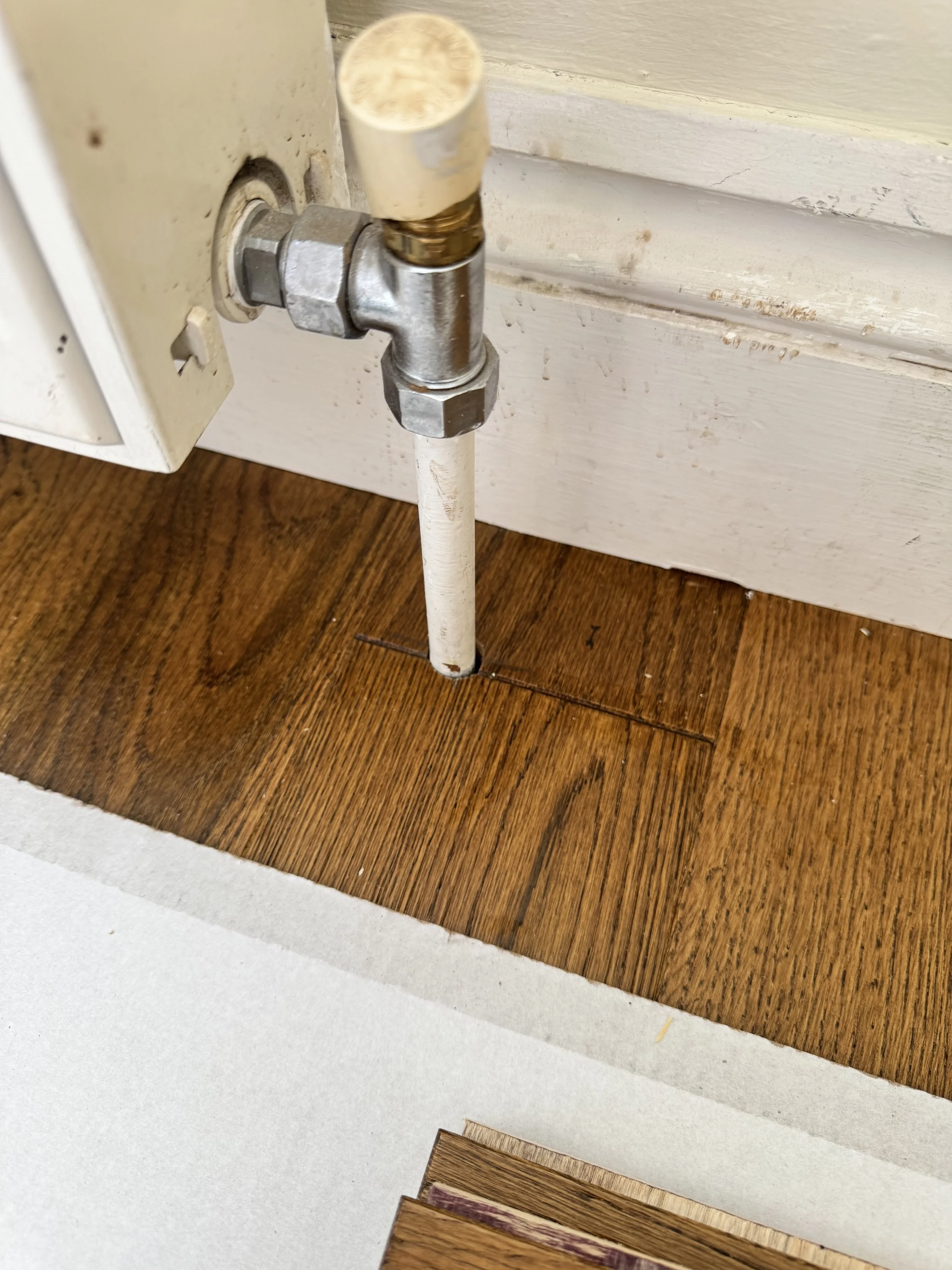 Precision cut wood flooring around radiator pipe during floor fitting in Coventry West Midlands