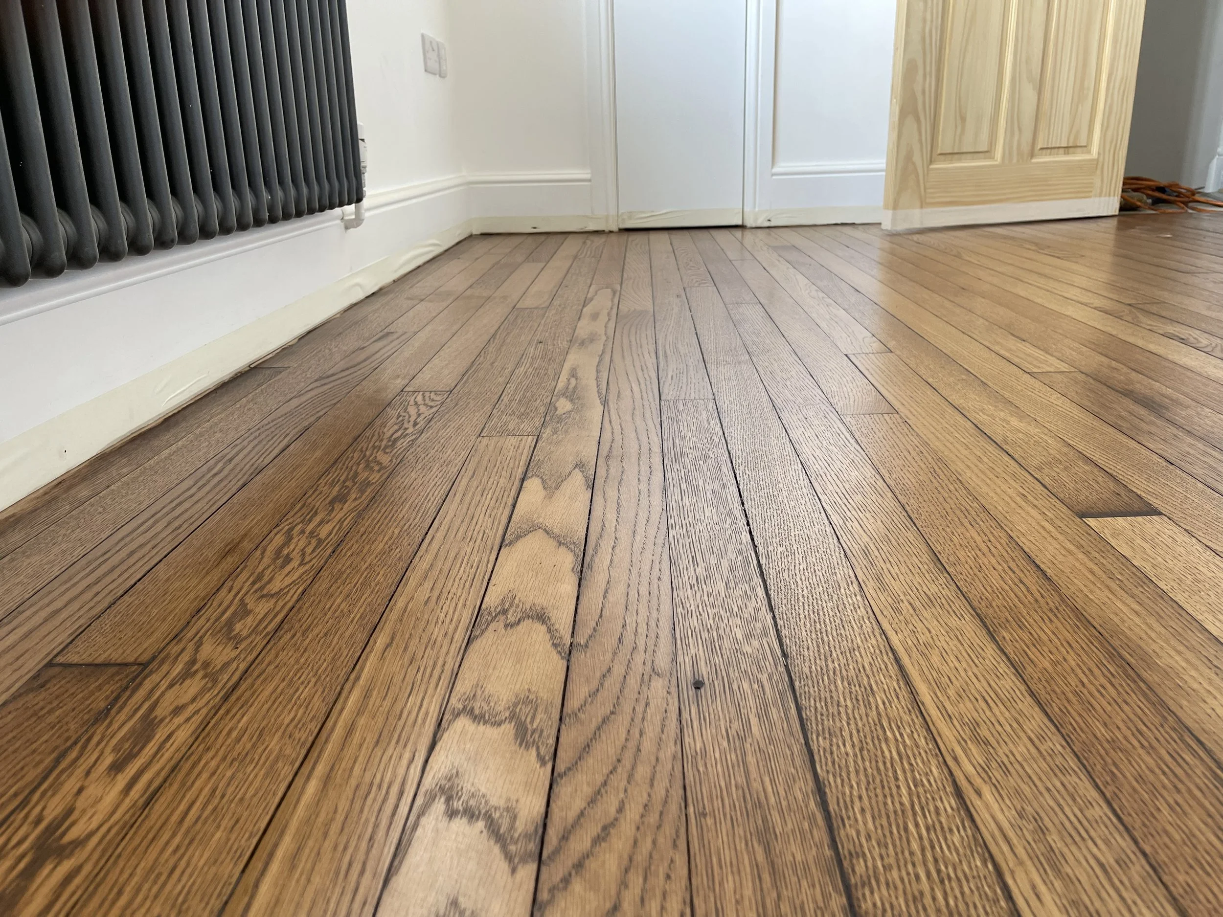 Close-up of a reclaimed solid oak strip floor in Bournville, Birmingham, after sanding, restoration, and finishing with a coloured oil