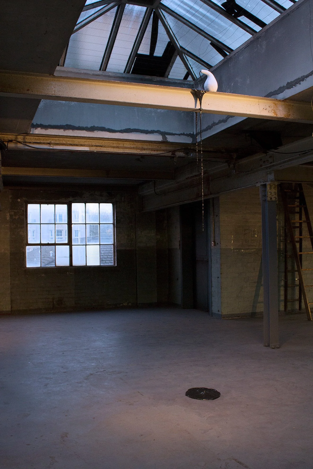 An industrial-style attic with a metal ceiling, a skylight, and a window on the brick wall. A white ceramic sculpture is on the metal beam, with liquid dripping from it. The room has exposed bricks, metal beams, and a ladder on the right side.