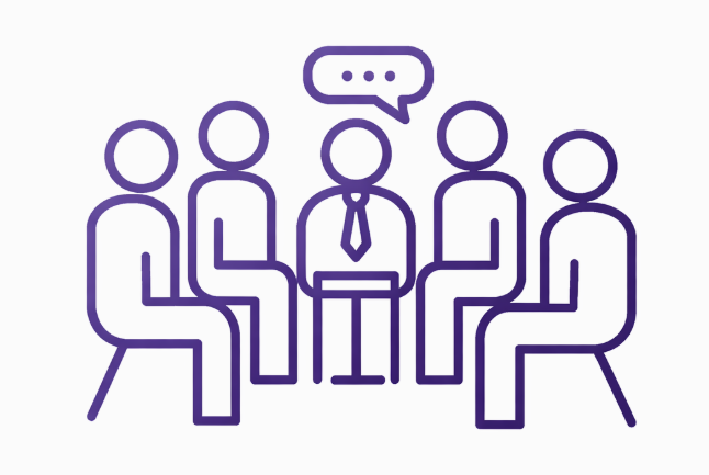 Five people sitting in a circle, with one person in the center speaking, represented by a speech bubble with three dots.