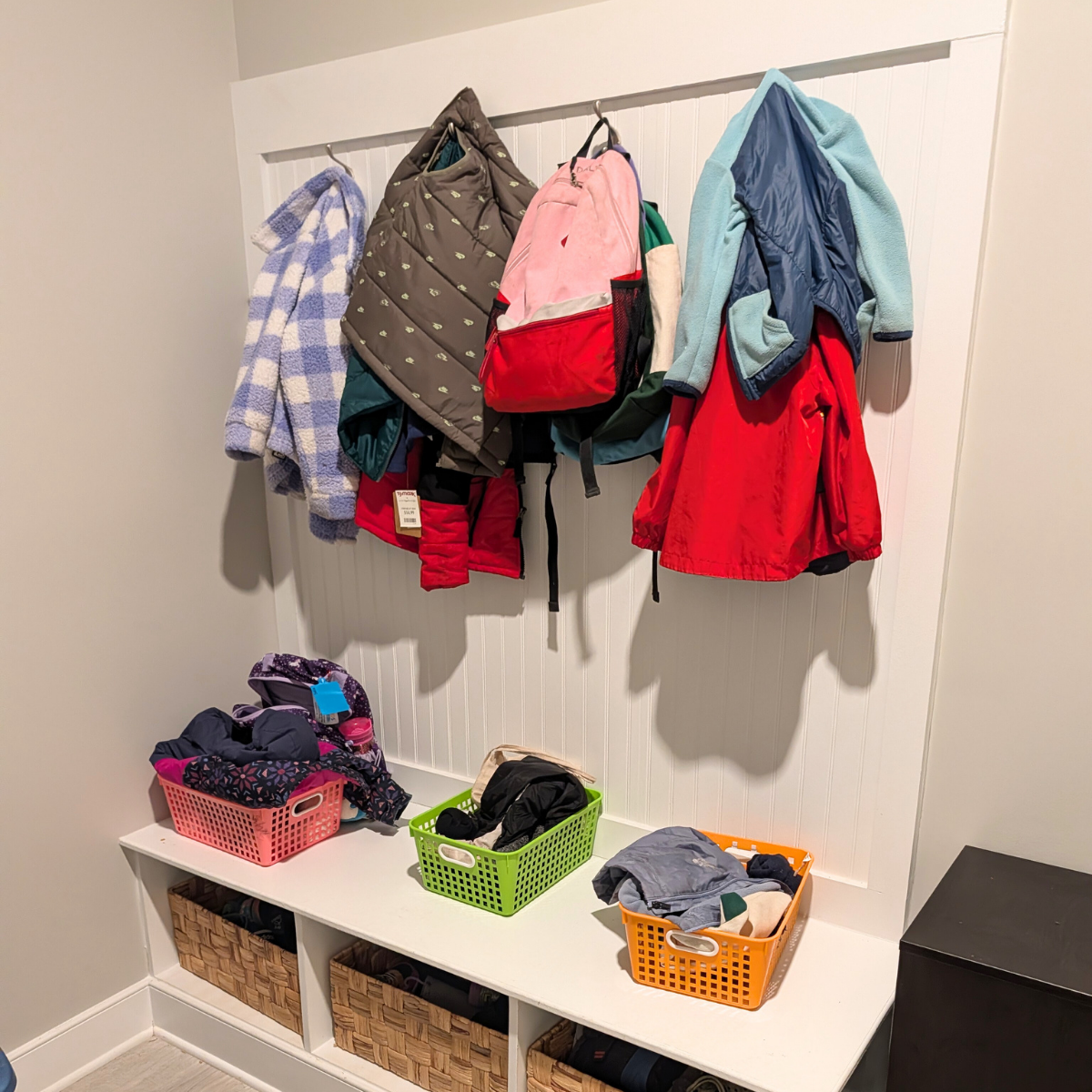 Organized mudroom of children's coats and bags