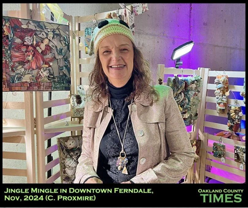 A smiling woman with curly hair wearing a festive hat, beige jacket, and a necklace, standing in front of holiday-themed decorations and artwork at an event called Jingle Mingle in Downtown Ferndale, Oakland County, November 2024.