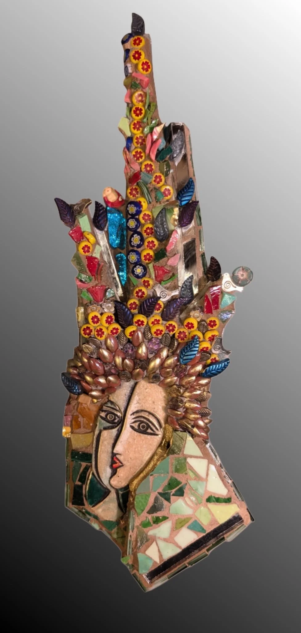 Mixed media art piece featuring a woman's face with curly hair made of metallic beads, and colorful mosaic details including flowers, leaves, and geometric shapes.