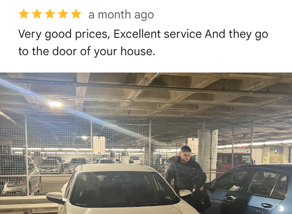 A man standing next to a white car in an underground parking garage, with other cars and concrete pillars visible in the background.