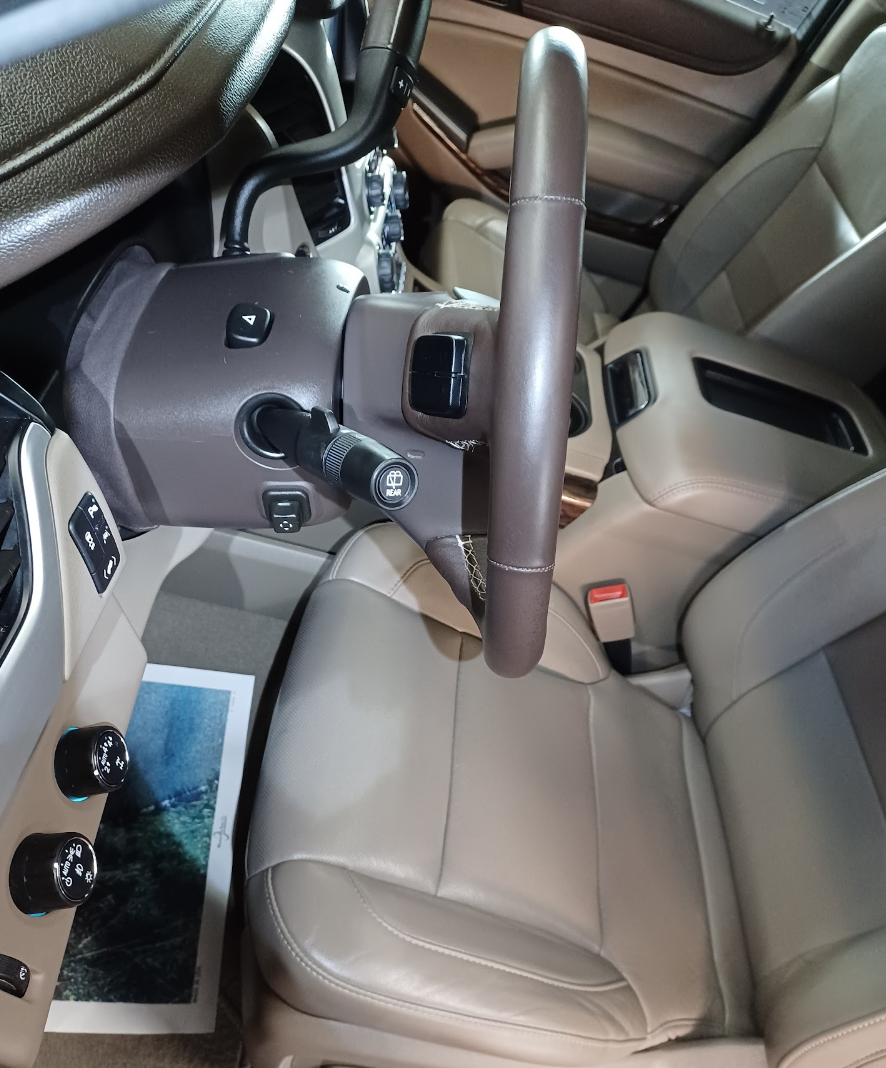 Interior of a vehicle showing the steering wheel, dashboard, and front seats.