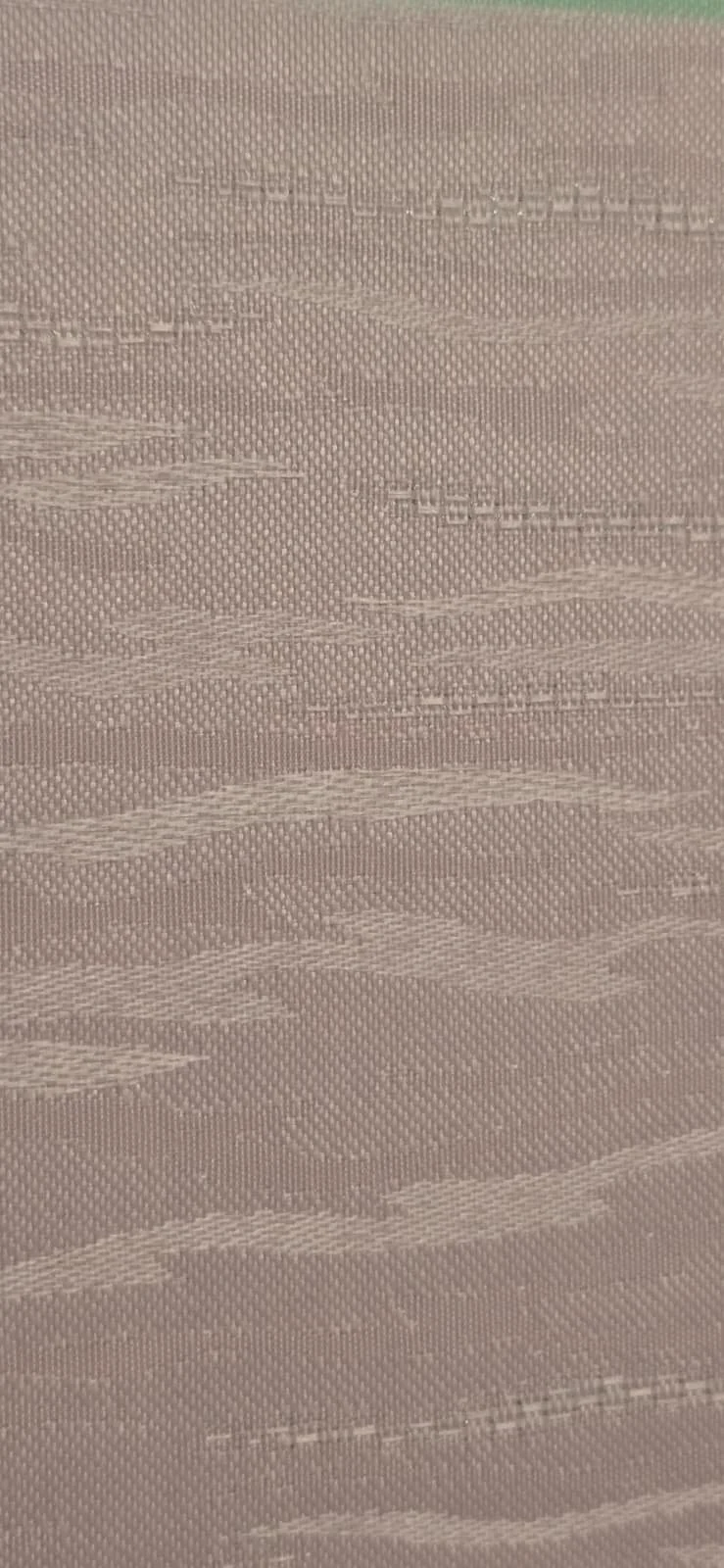 Close-up of a textured fabric with horizontal wavy lines and weave patterns.