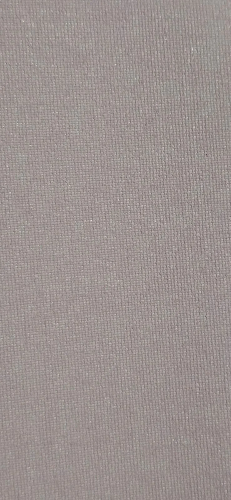 Close-up of a textured, light pink or beige fabric surface.