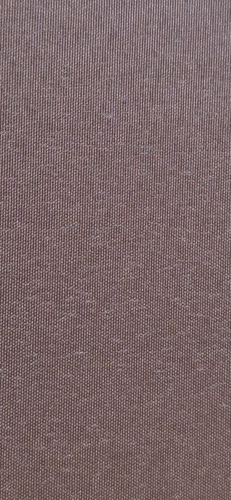 Close-up of a brown textured fabric with a subtle floral pattern woven into it.