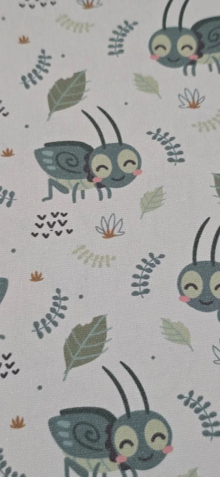 Pattern of cartoon bees with blue wings, smiling faces, pink cheeks, surrounded by green leaves, small flowers, and abstract shapes on a white background.