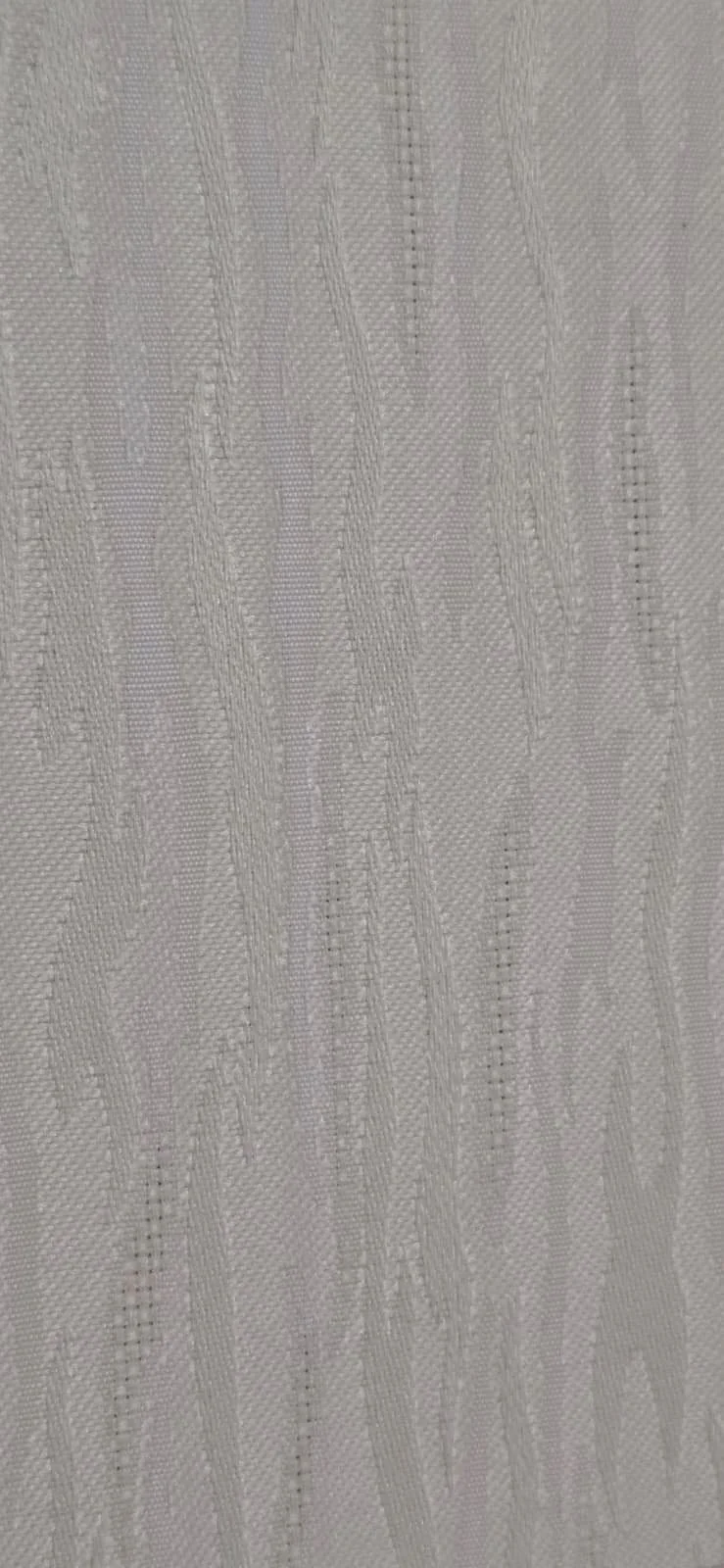 Close-up of a textured, light-colored fabric or wallpaper with subtle linear and geometric patterns.
