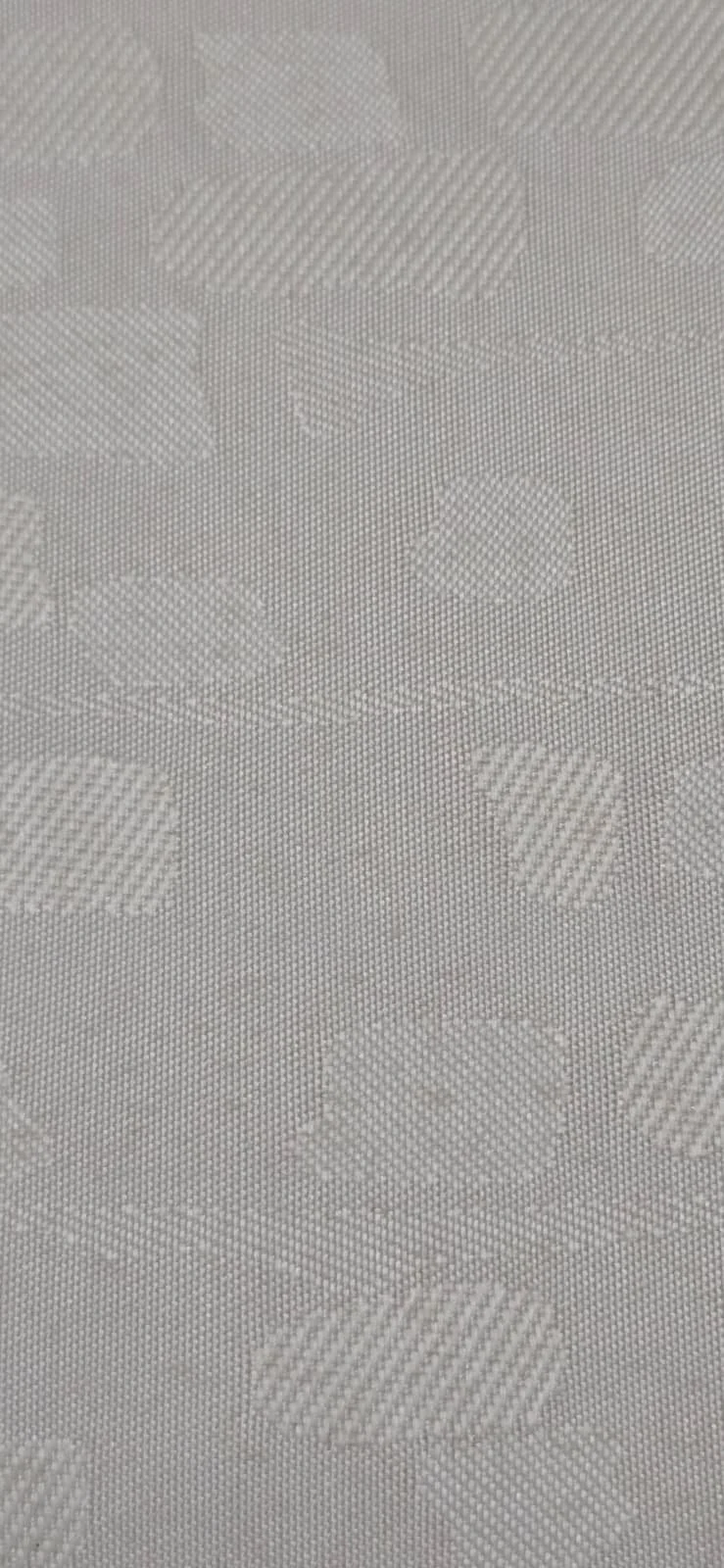 Close-up of a white textured fabric with a floral pattern.