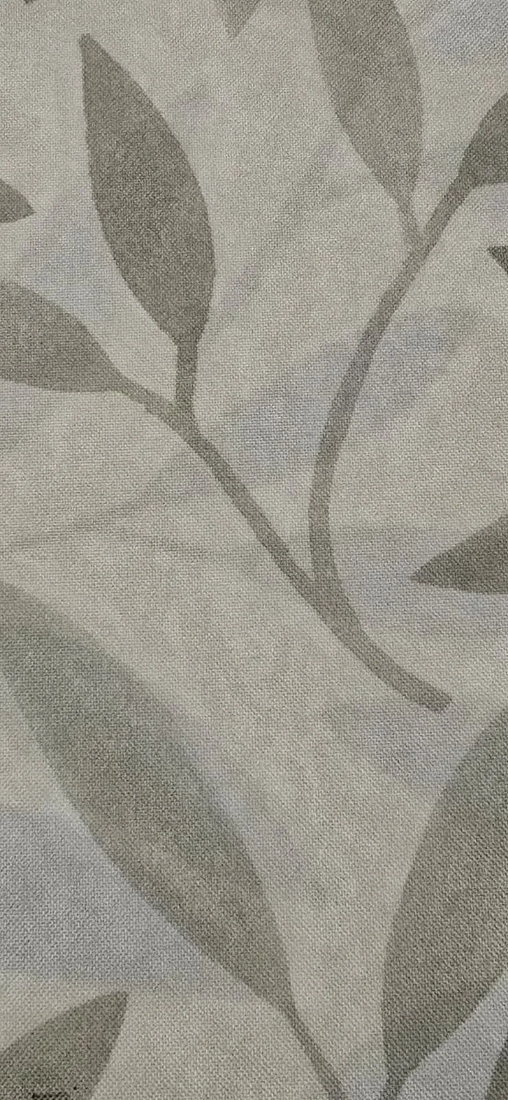 Close-up of a fabric with a light-colored background and a pattern of gray leaves and stems.