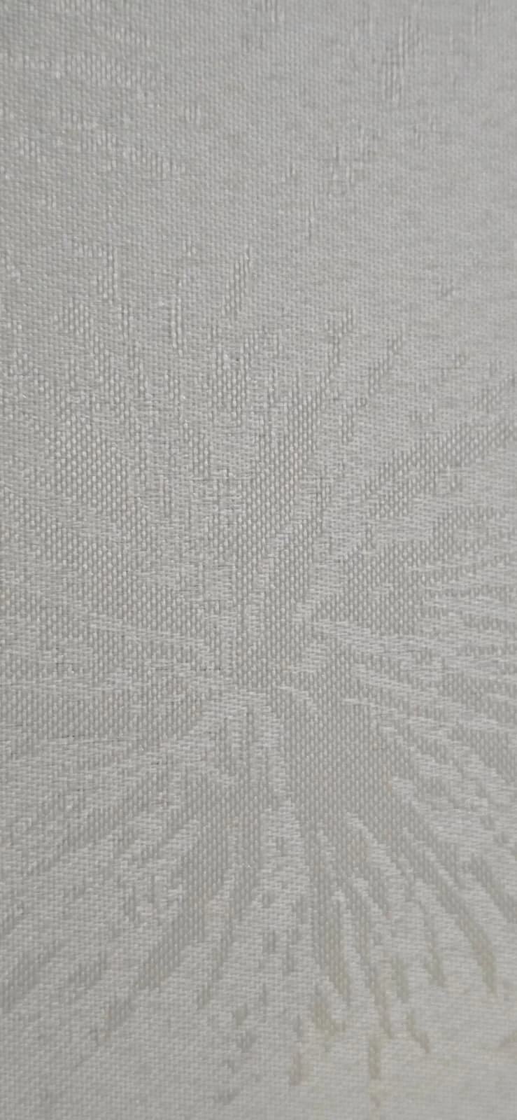 Close-up of a textured, light-colored fabric with a floral or botanical pattern woven into it.