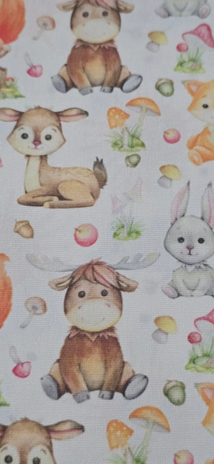 Pattern of illustrated woodland animals including a bunny, deer, and a fawn with mushrooms and berries on a light background.