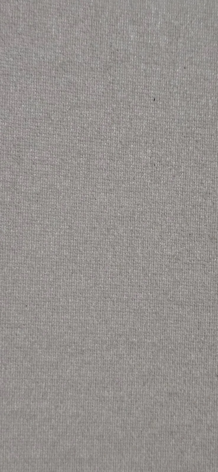 Close-up of a beige or light gray fabric surface with a tight weave pattern.