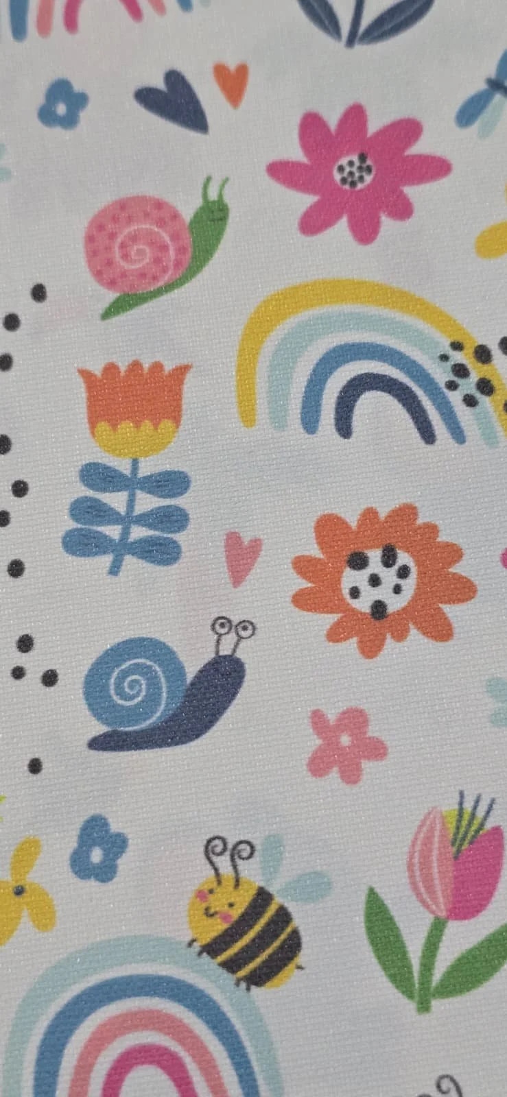 Pattern with flowers, a rainbow, snails, a bee, a butterfly, hearts, and colorful dots on a white background.