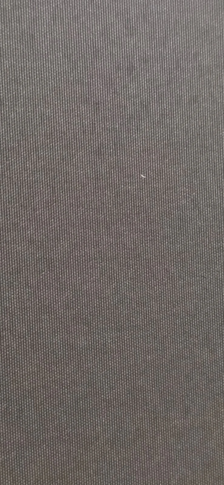 Close-up of a textured, dark gray fabric surface with tiny, evenly spaced patterns.