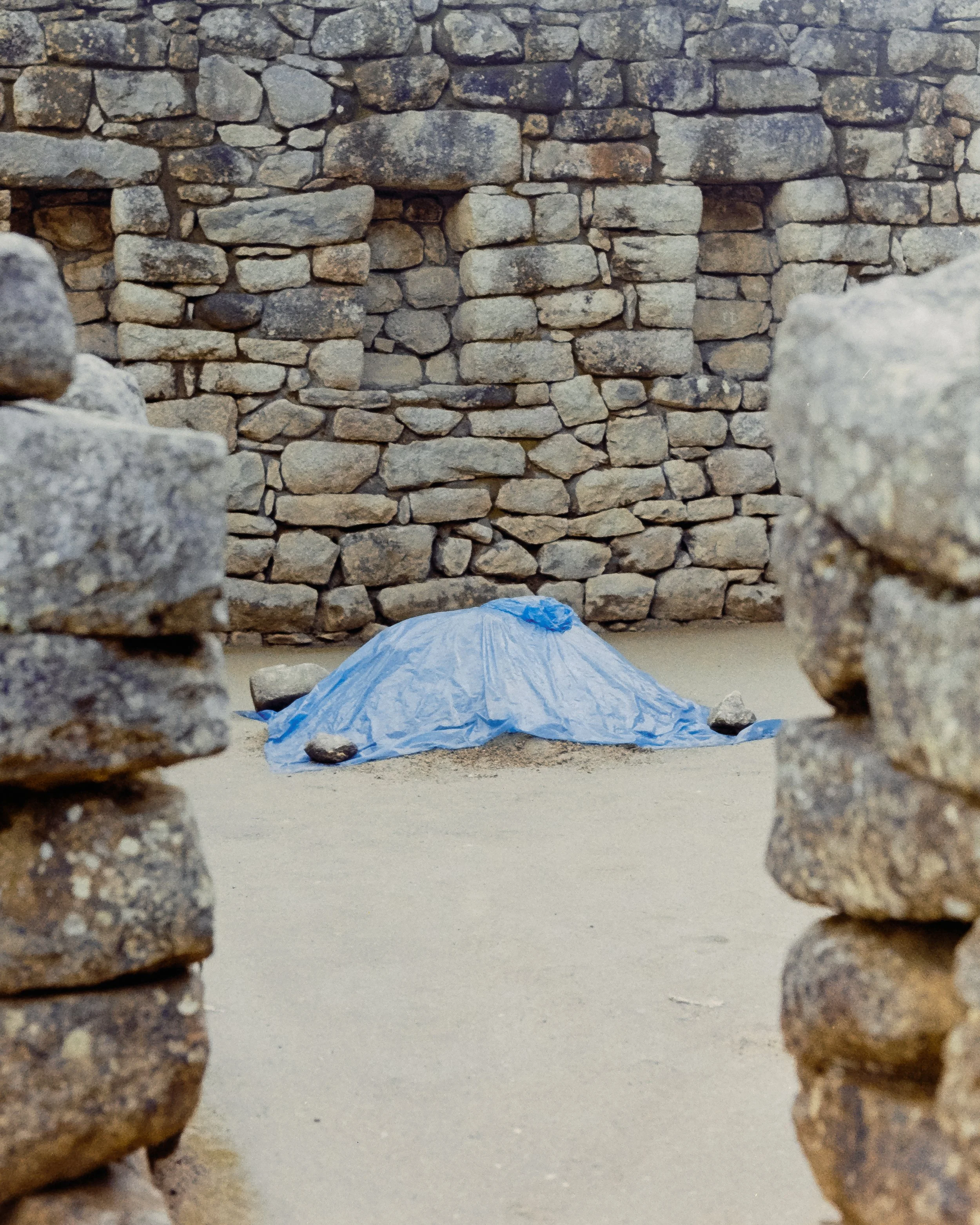 Conceptual photograph by Amador Z of blue fabric covering something on stone terraces in Machu Picchu