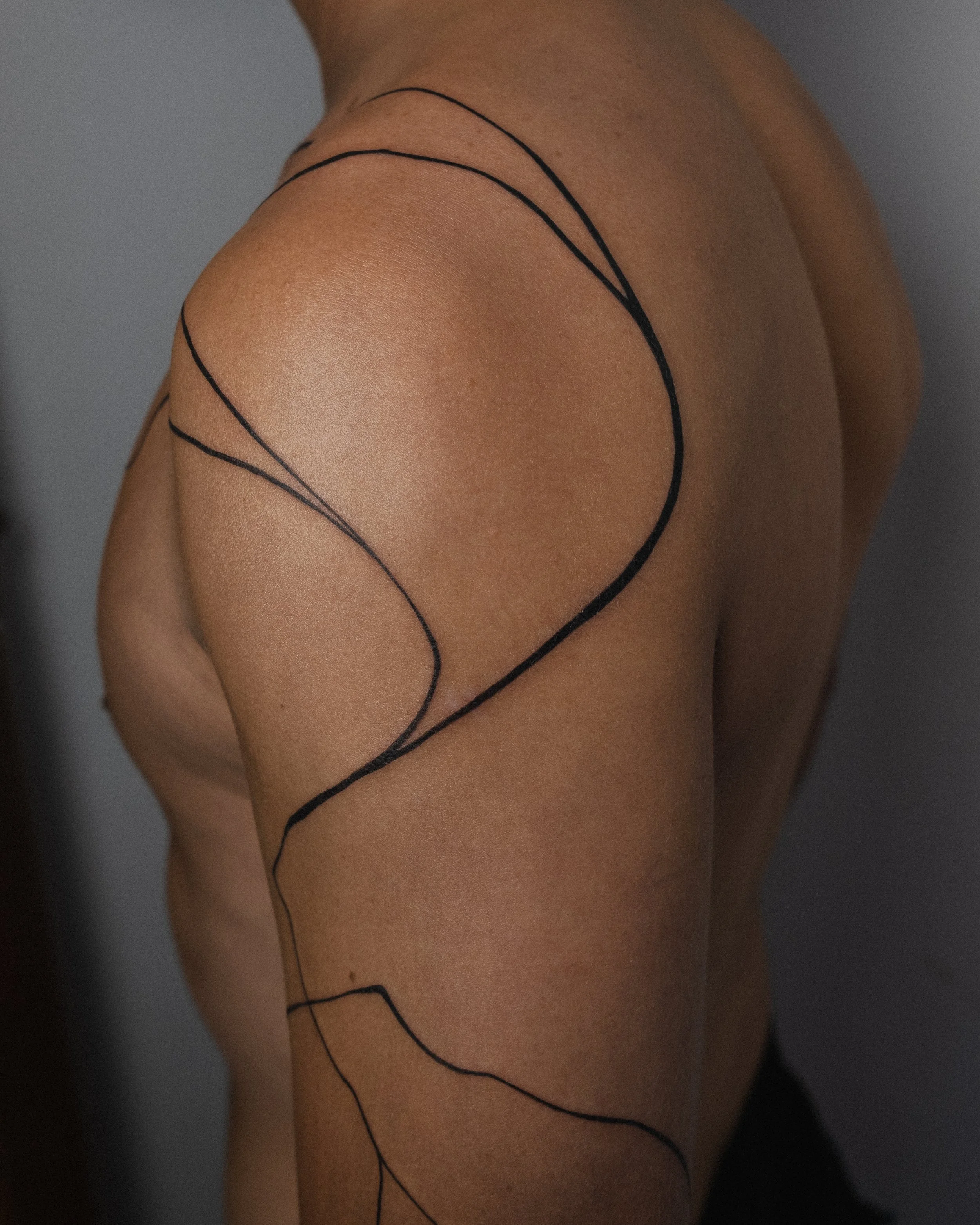 Freehand abstract line tattoo on a back and shoulder by Amador Z