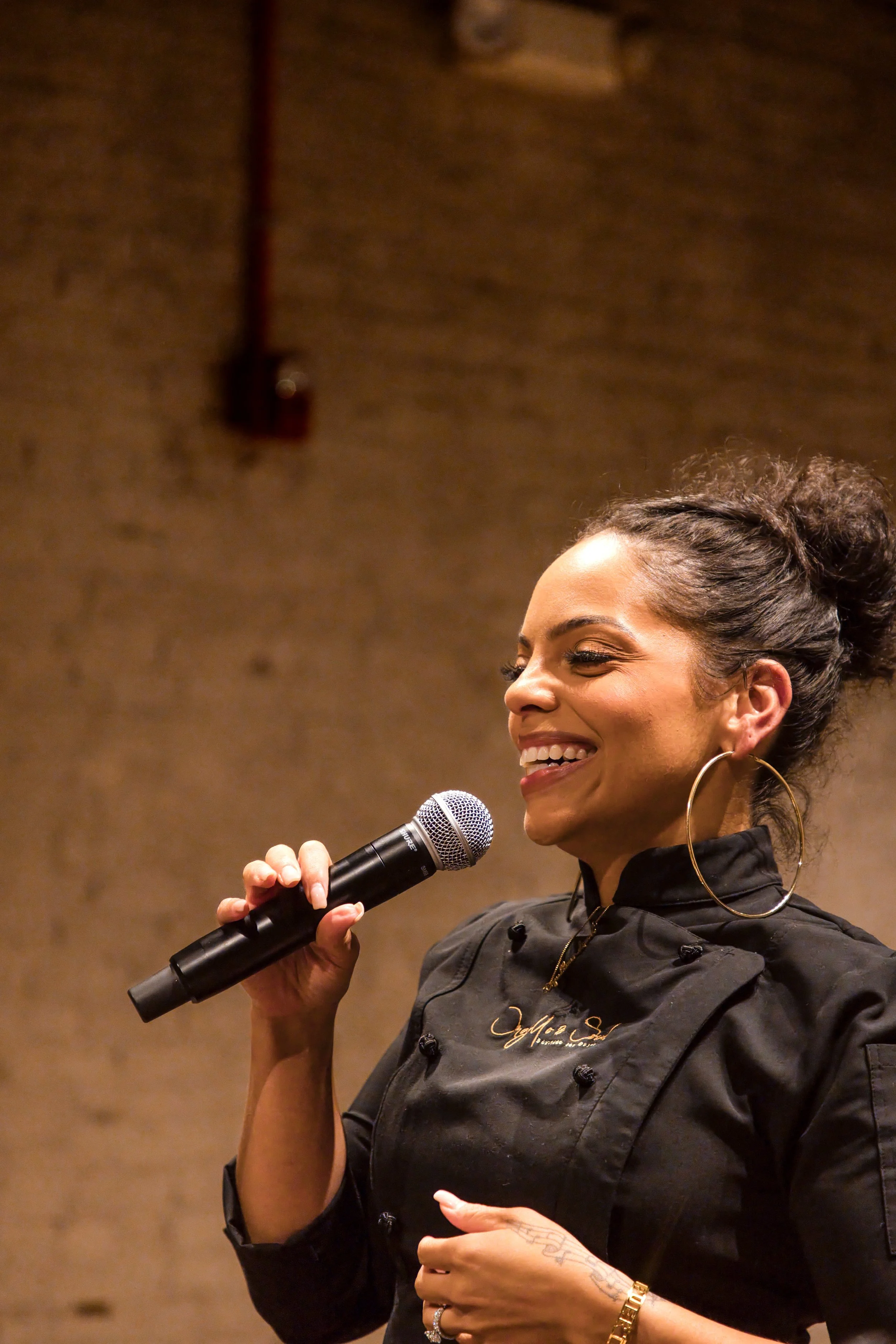Chef speaking to guests with a microphone at a private dinner event in Baltimore
