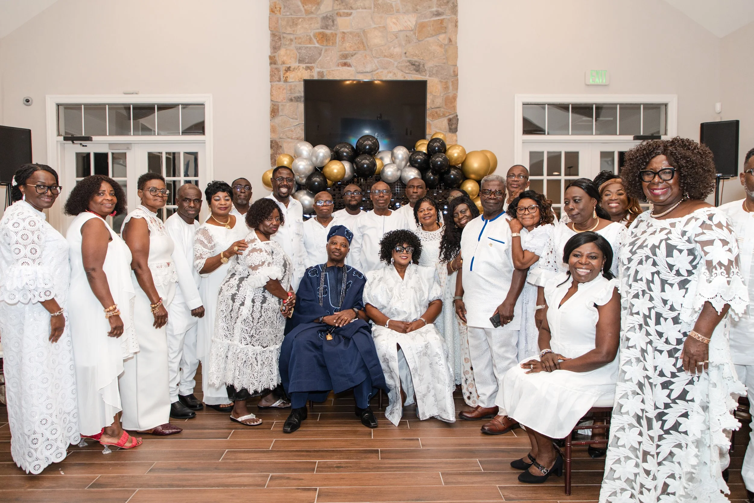 Large group dressed in white posing together at an indoor celebration