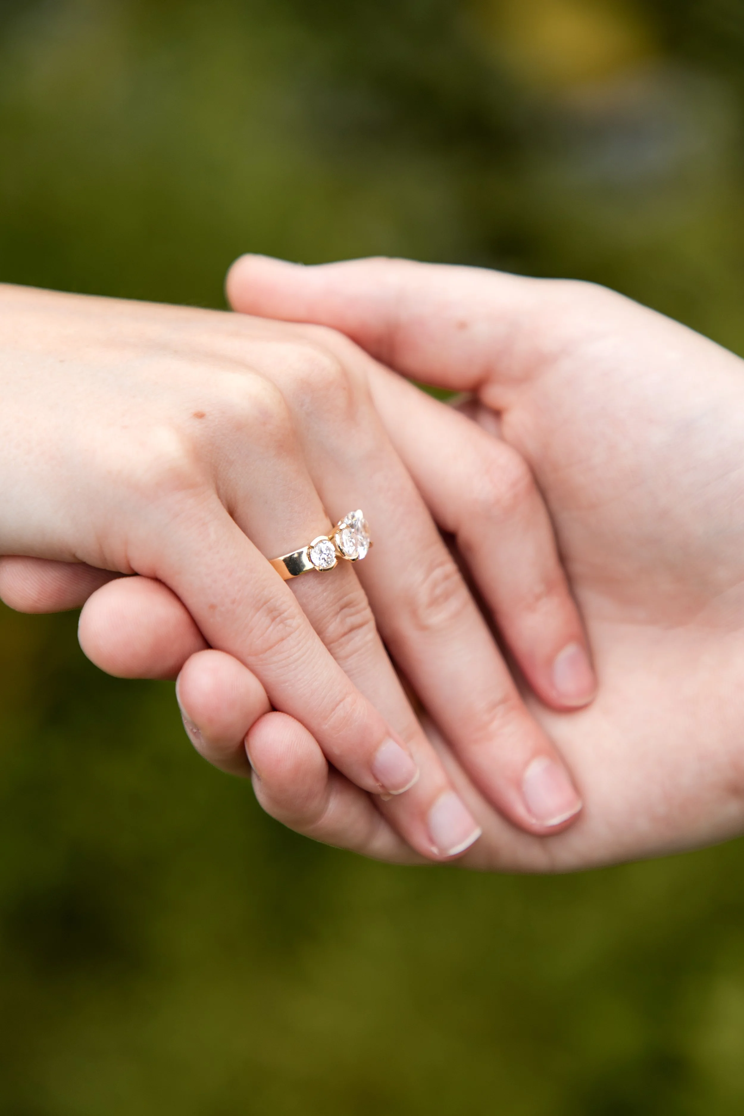 Couple holding hands showing off a new engagement ring
