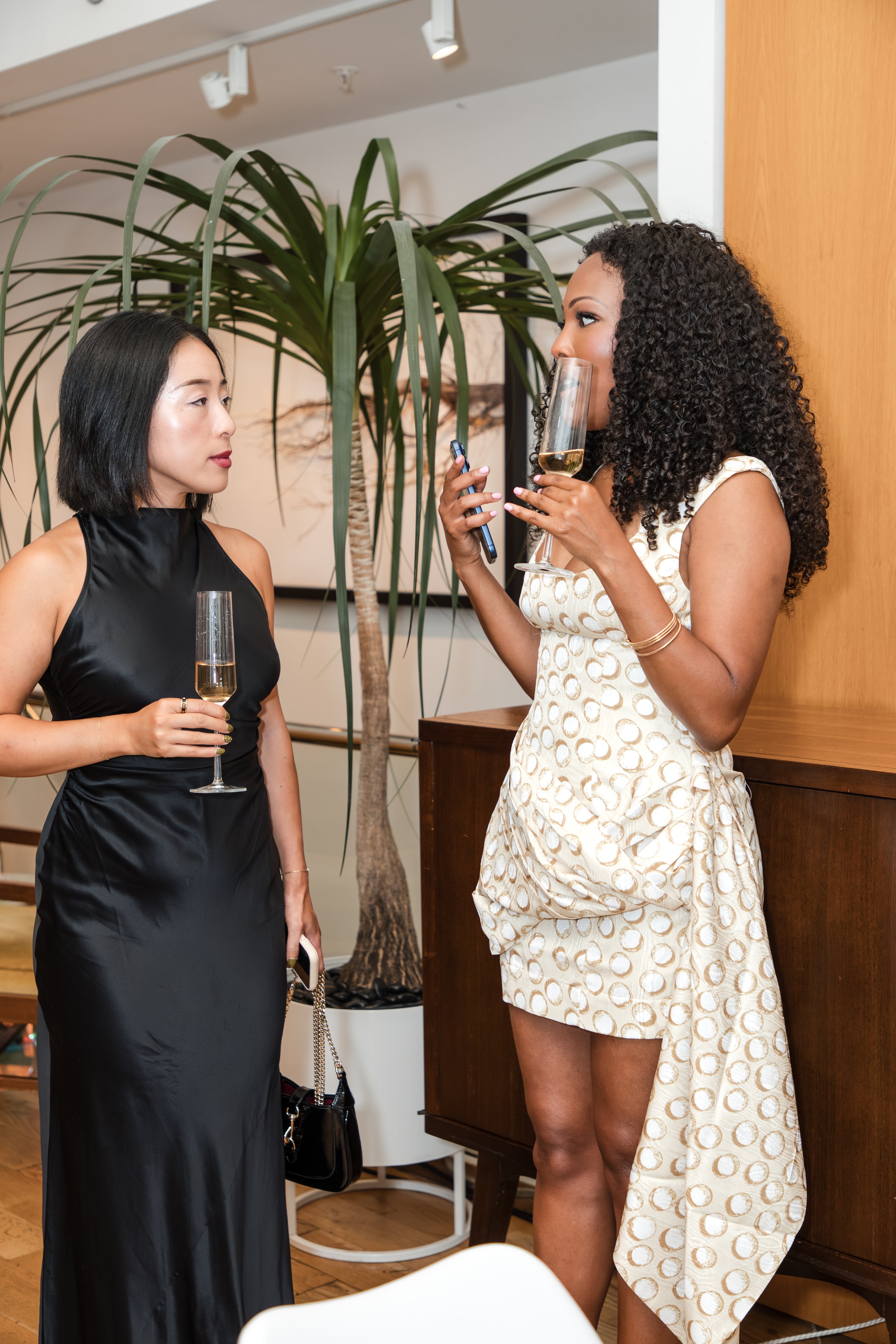 Two guests chatting with drinks at a stylish indoor event