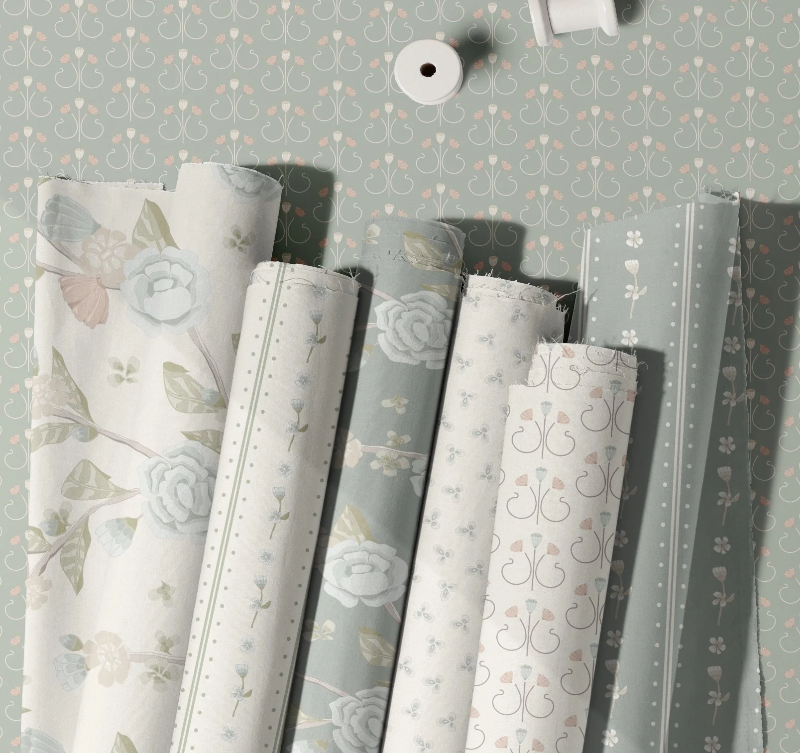 Various rolls of wallpaper with floral and geometric patterns in soft pastel colors, laid out on a flat surface.
